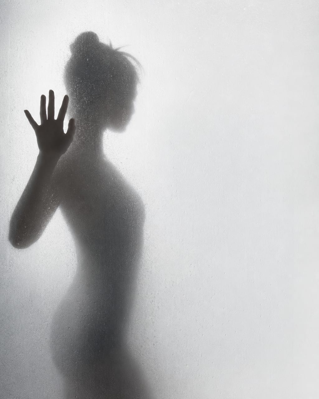 人物深色剪影被磨砂玻璃窗背光勾勒，玻璃上可见水珠，近乎黑白，带暖象牙色光晕。